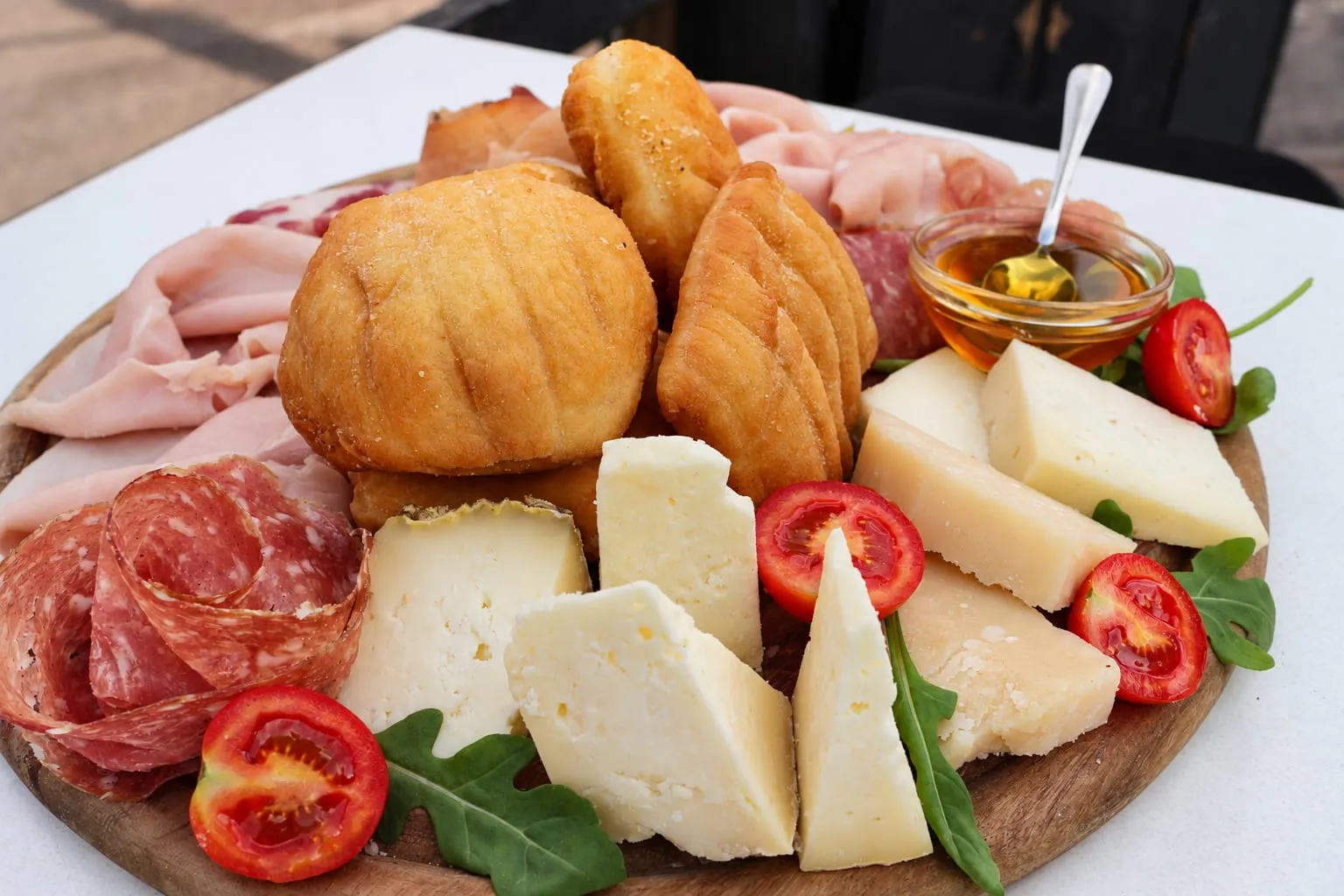 Tagliere con gnocco fritto, salumi, formaggi, pomodorini e miele